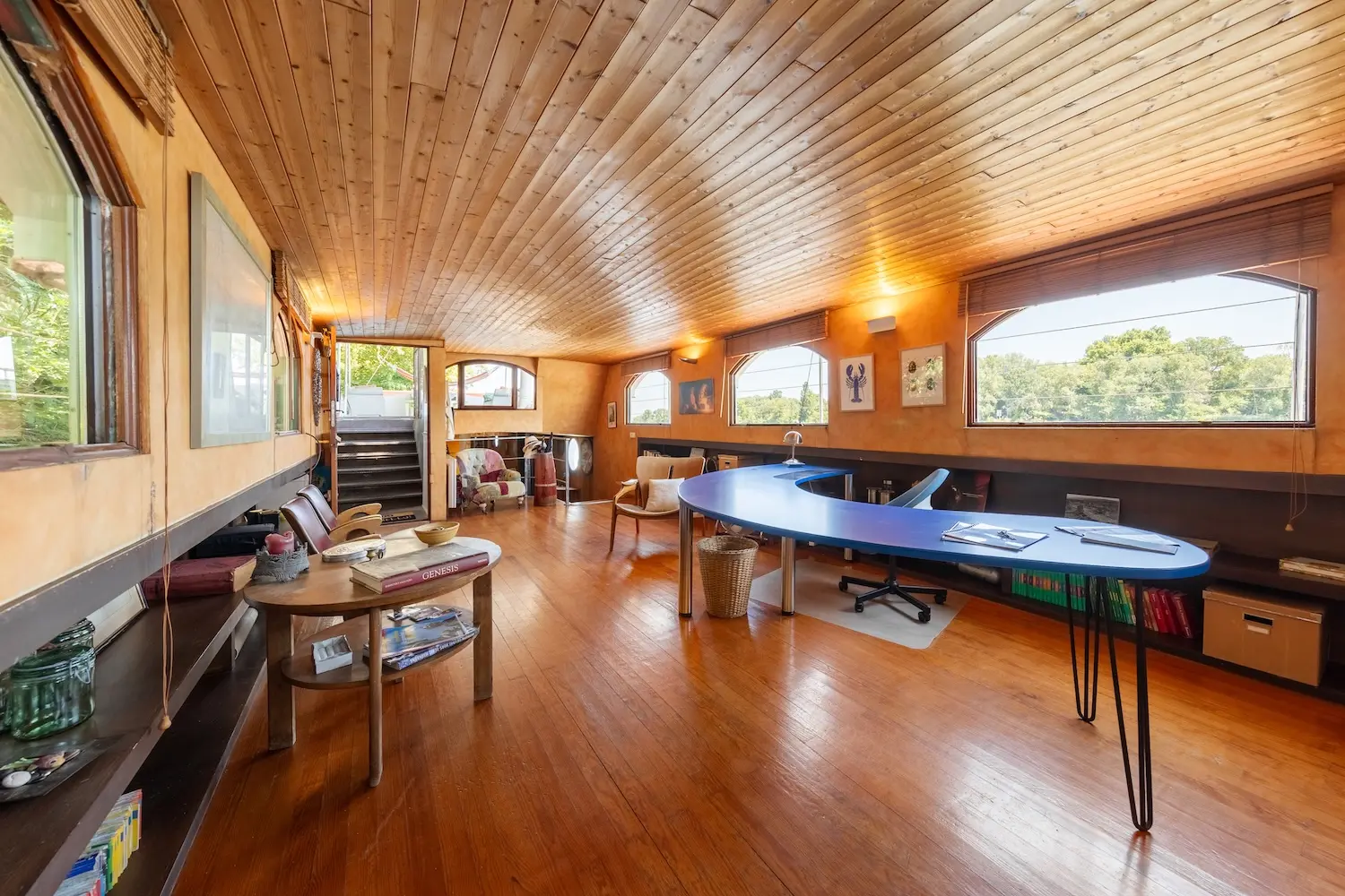 photo de la salle principale de la péniche La Paz, avec son bureau et une table basse